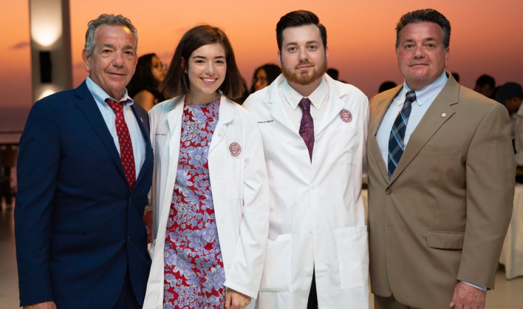 Cousins Jake and Emily Rienzo join their fathers and proud SGU graduates to accept their white coats at the Spring 2020 School of Medicine White Coat Ceremony