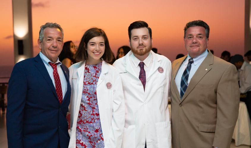 The Rienzo family standing with a sunset in the background at their White Coat Ceremony