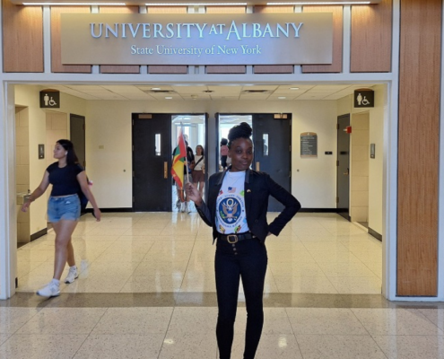 Alanda Joseph standing in front of "University at Albany sign"